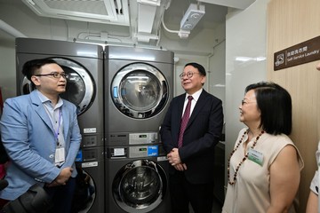 The Chief Secretary for Administration, Mr Chan Kwok-ki, today (July 11) officiated at the Hung Hom Community Living Room Opening Ceremony. The Secretary for Labour and Welfare, Mr Chris Sun, also officiated at the ceremony. Photo shows Mr Chan (centre) visiting the self-service laundry facilities to understand how they help improve the livelihood of subdivided unit households.