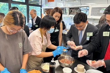 政务司司长陈国基今日（十月三日）主持第六届扶贫委员会第一次会议，并率领委员参观土瓜湾社区客厅。医务卫生局局长卢宠茂教授、劳工及福利局局长孙玉菡、民政及青年事务局副局长梁宏正和教育局副局长施俊辉亦有随行。图示孙玉菡（右二）在共享备餐间与受惠家庭制作小食。